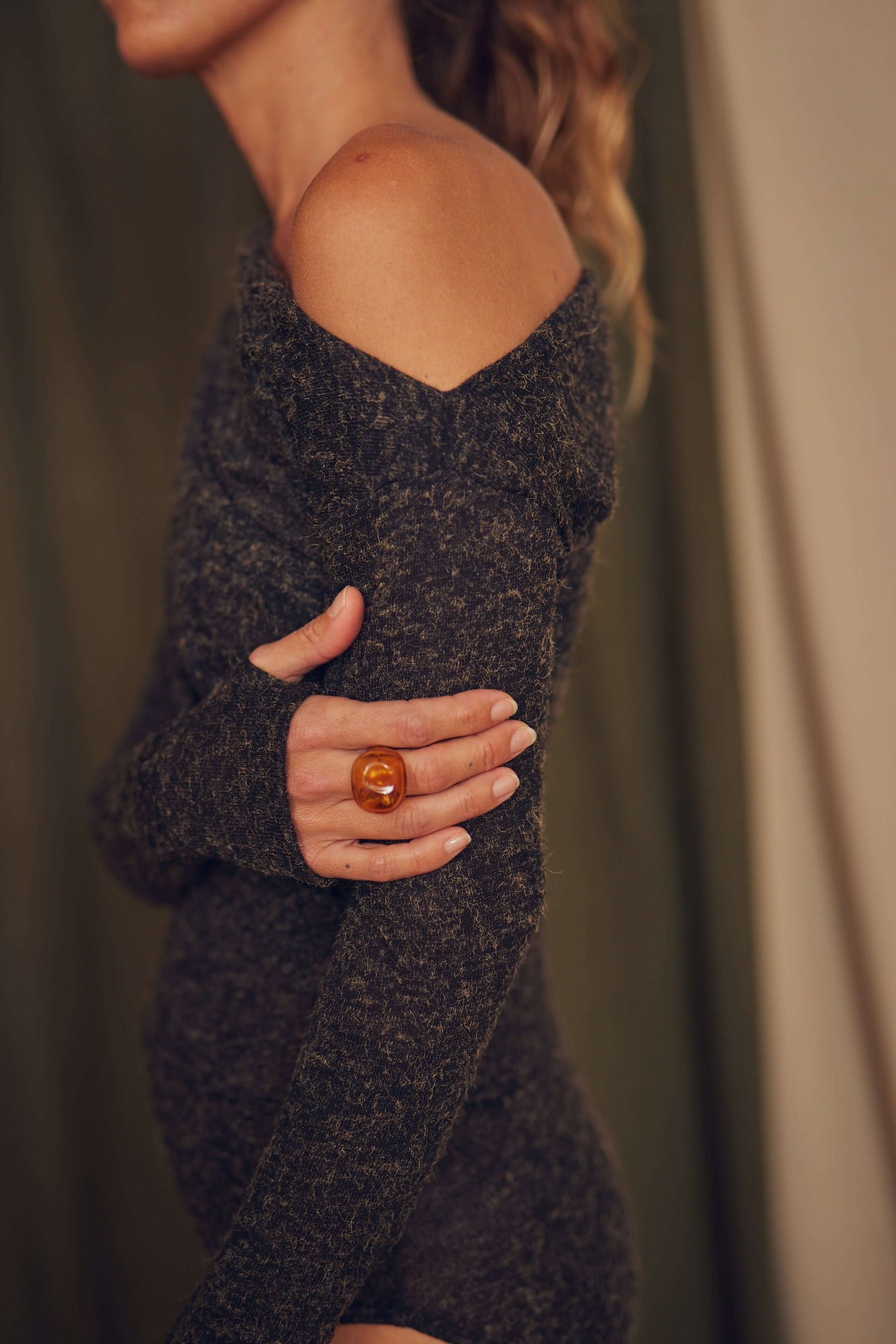 Model wearing a black recycled jersey drape bodysuit, showcasing a stylish off-shoulder design and long sleeves.