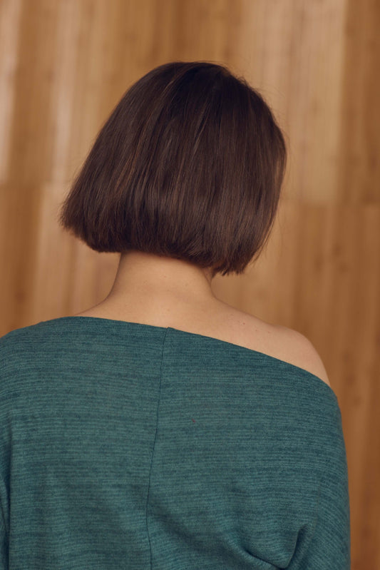 Back view of a model wearing a Teal Drape Top with a drape neckline, showcasing sustainable style.