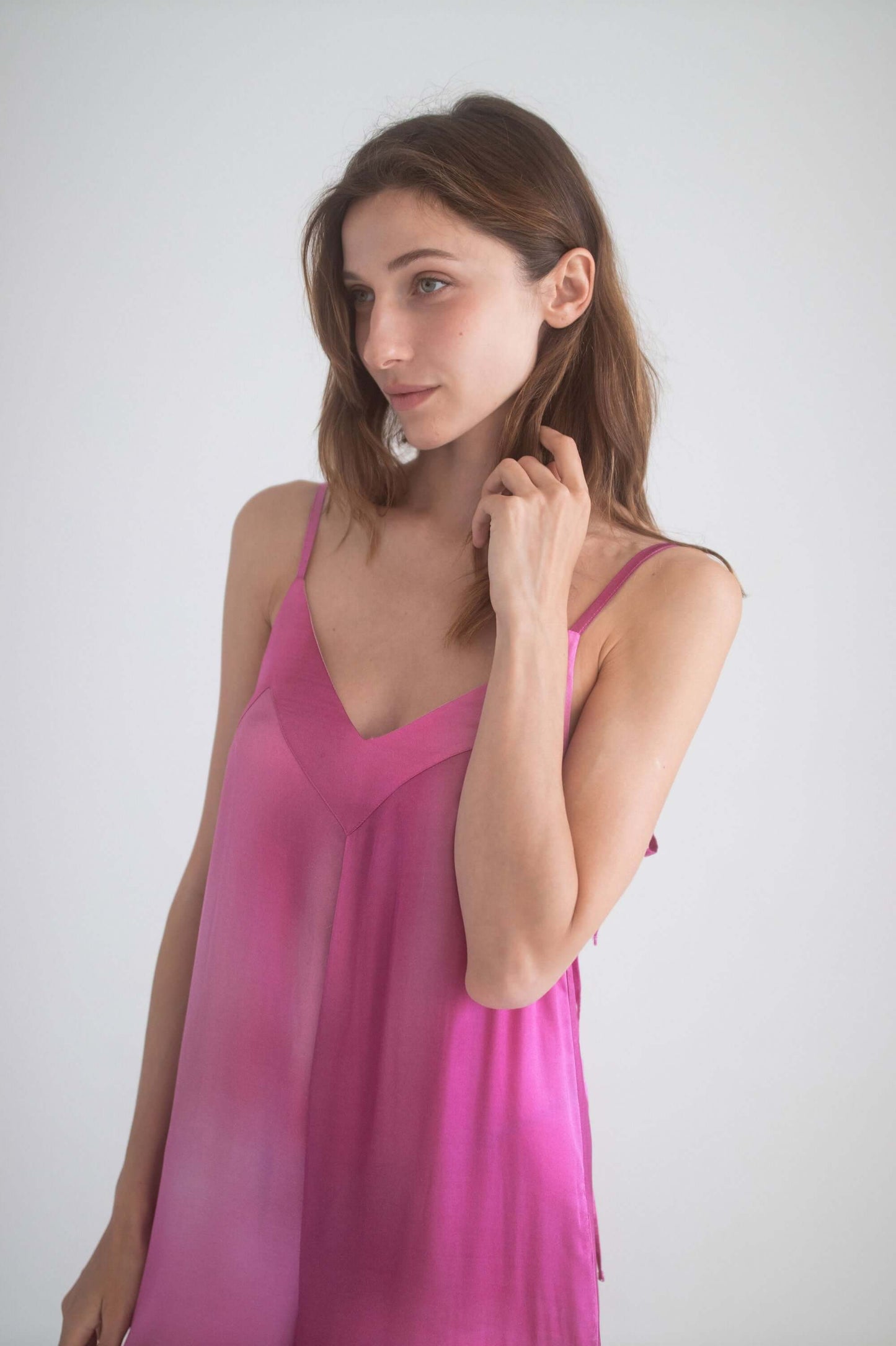 Model wearing a lightweight pink silk camisole dress with adjustable straps, showcasing a stylish and breezy look.