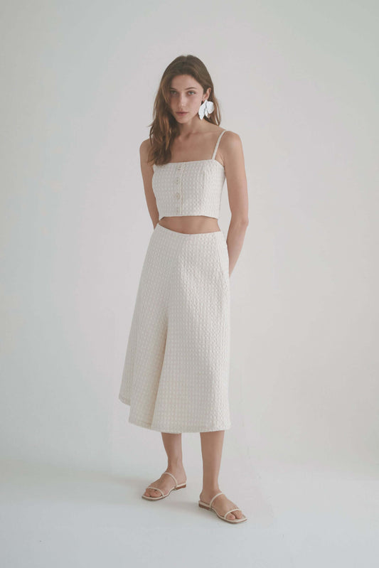 Model wearing ecru waffle skirt culottes paired with a matching crop top, showcasing elegance and comfort in sustainable fashion.