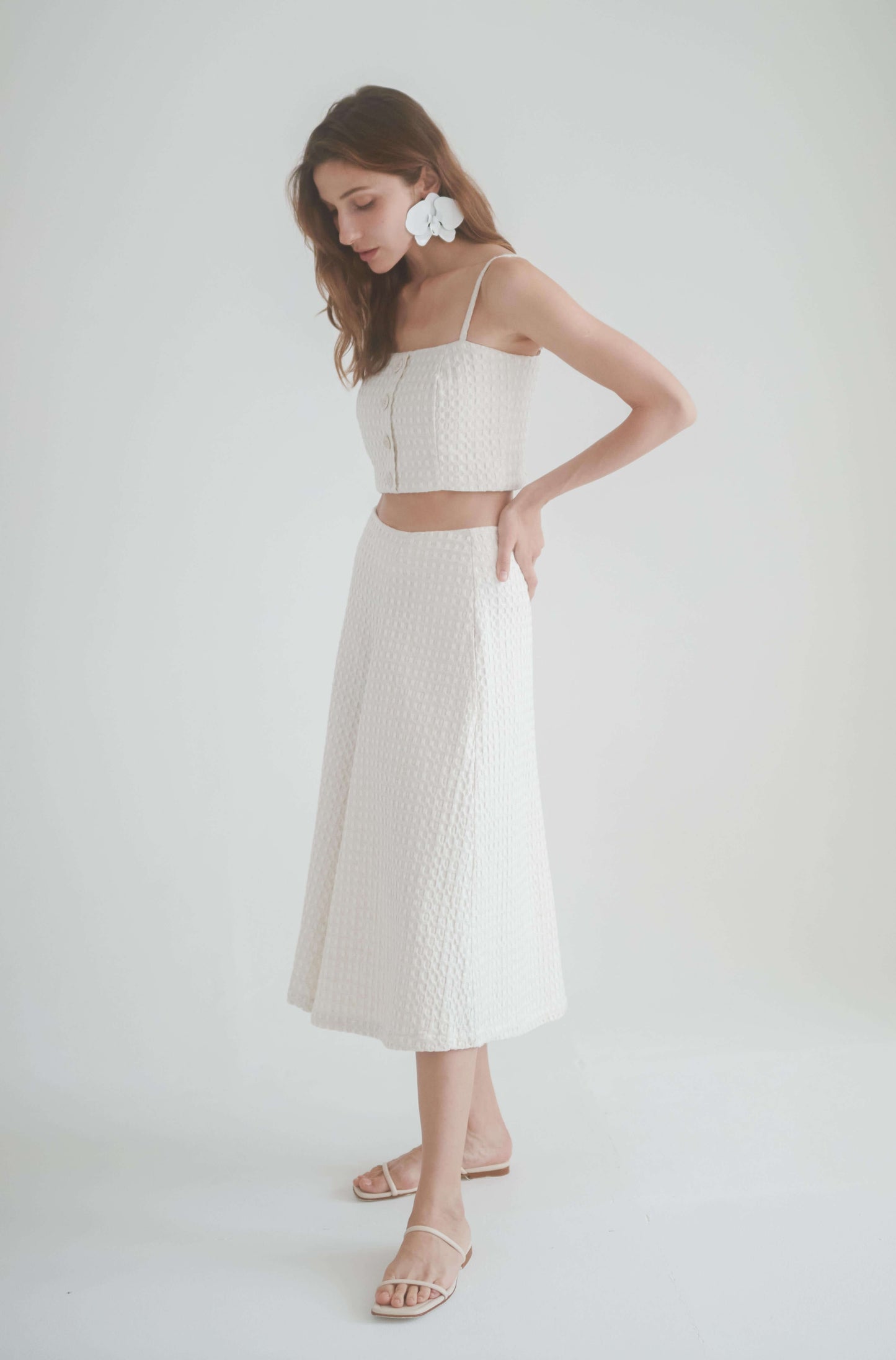 Model wearing ecru waffle skirt culottes with matching crop top and sandals, showcasing chic summer style.