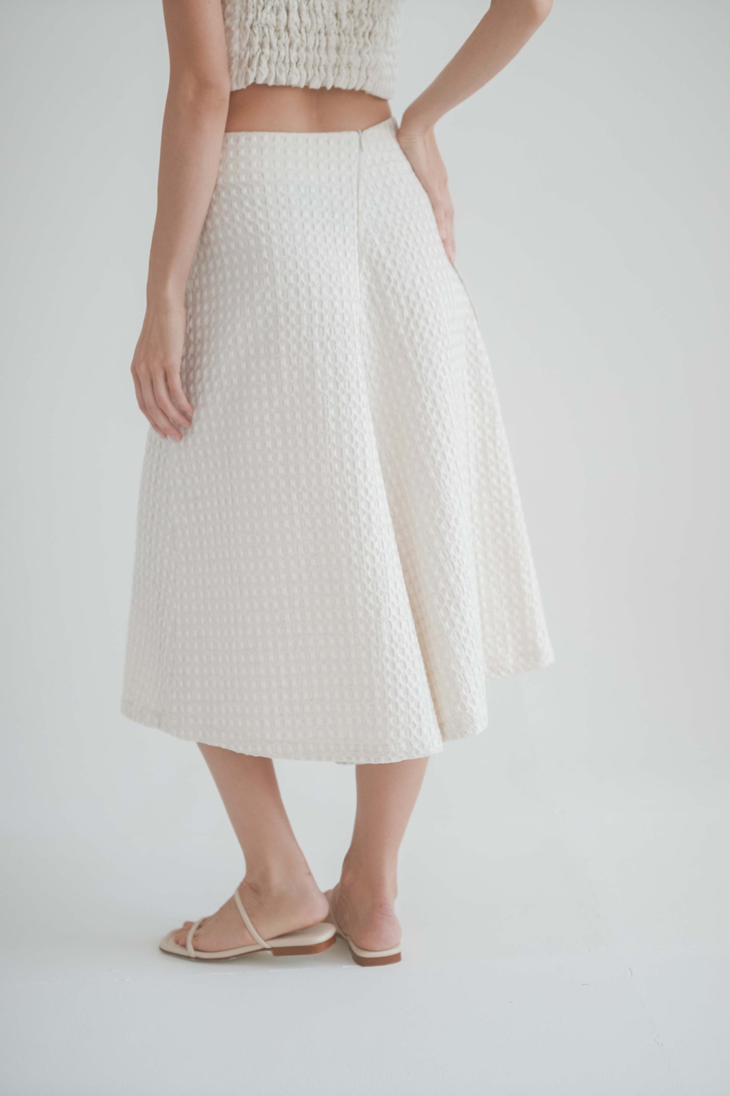 Back view of ecru waffle skirt culottes, showcasing A-line silhouette and sustainable fabric.