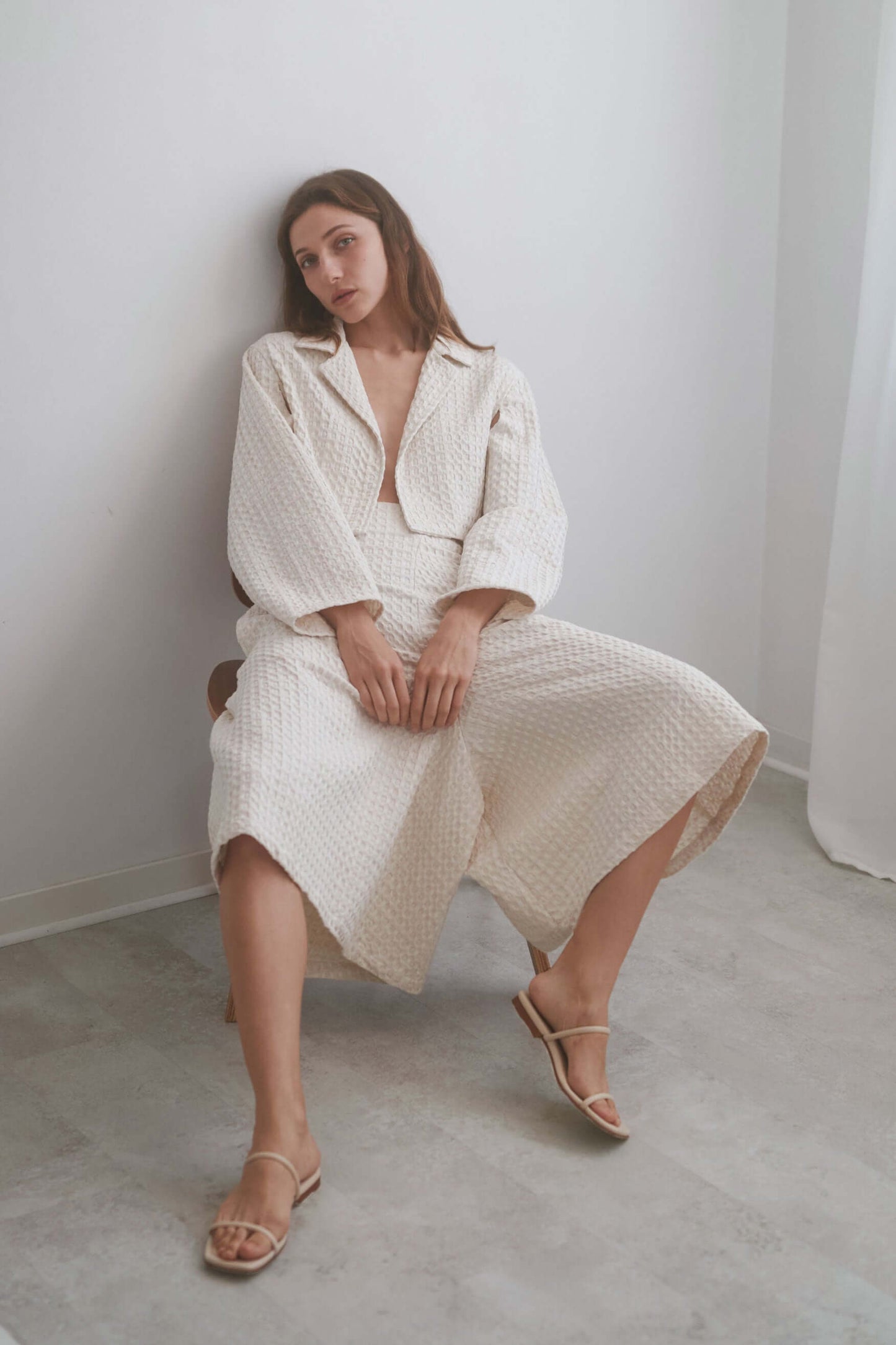 Model in ecru waffle culottes and matching top, showcasing stylish comfort and versatile fashion in a minimalistic setting.