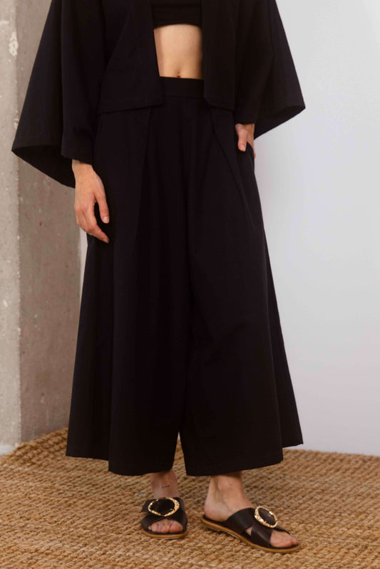 Organic Cotton Wide Culottes in Black, featuring a relaxed silhouette and cropped design, styled with sandals.