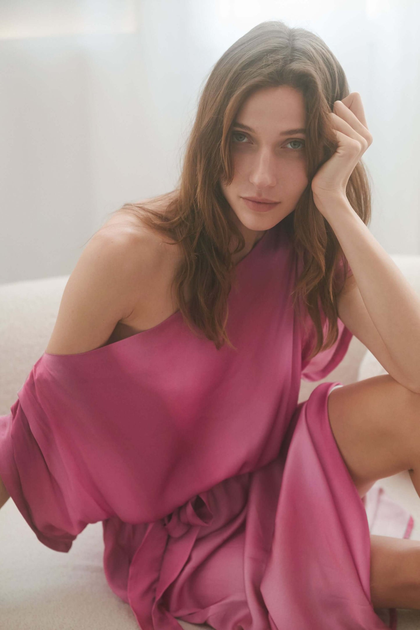 Model wearing an off-shoulder pink printed drape dress, showcasing its lightweight fabric and elegant design.