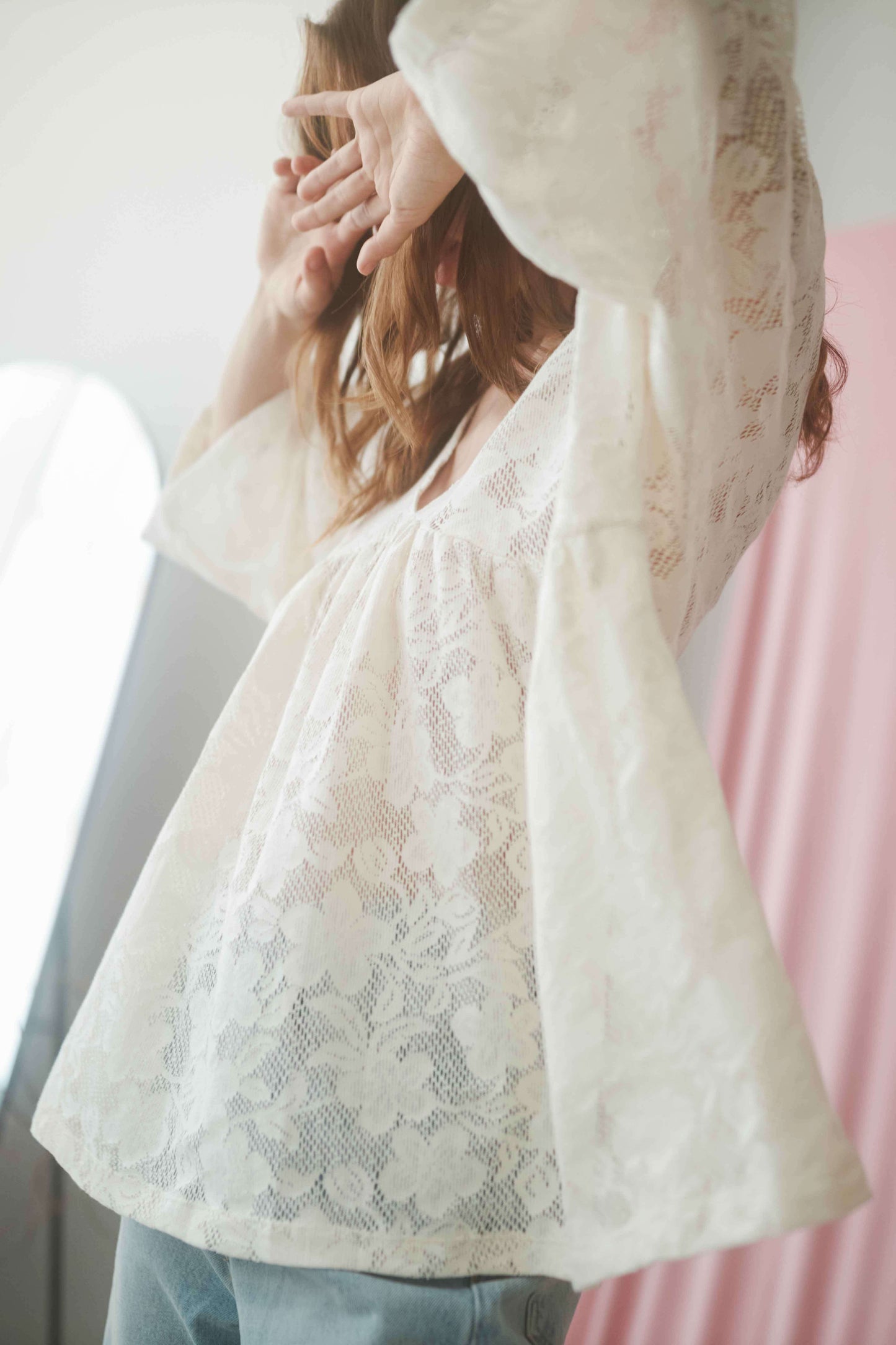 Model wearing ecru lace boho tunic top with V-neckline and wide sleeves, showcasing relaxed fit and organic cotton fabric.