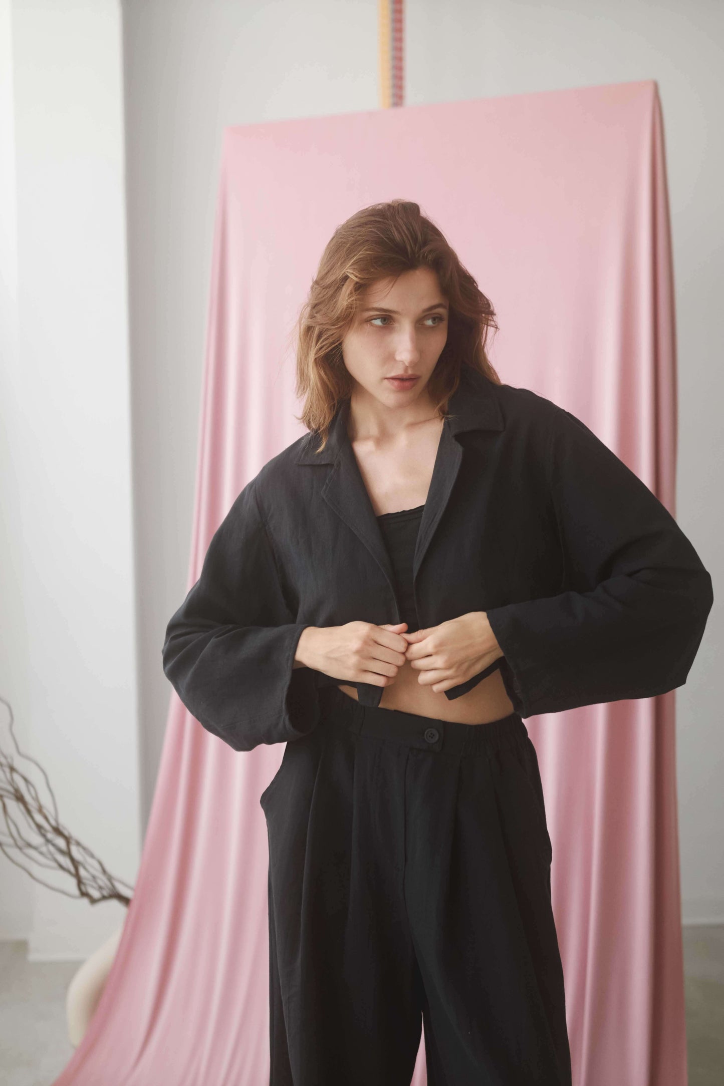 Model wearing a black cropped jacket, showcasing its stylish design and comfortable fit.