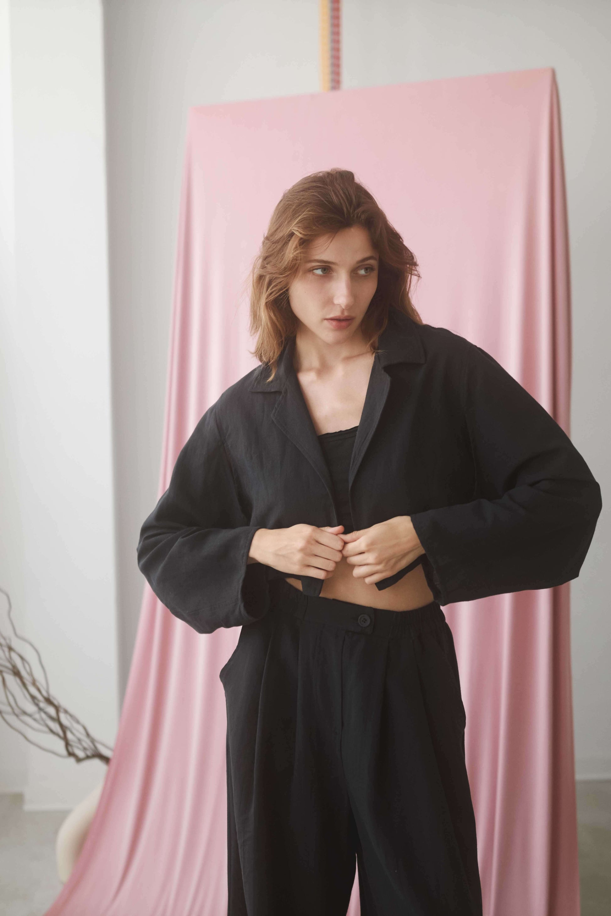 Model wearing a black cropped jacket, showcasing its stylish design and comfortable fit.