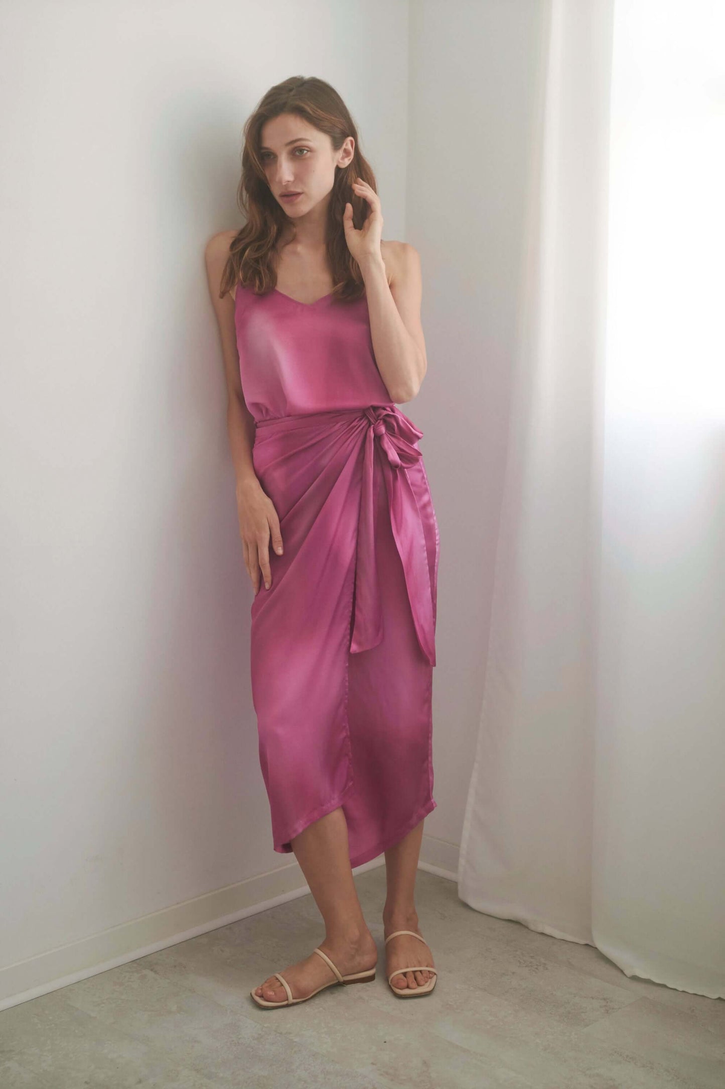 Model wearing a pink PRINT WRAP MIDI SKIRT with self-tie closure, showcasing the luxurious Ecovero viscose fabric.