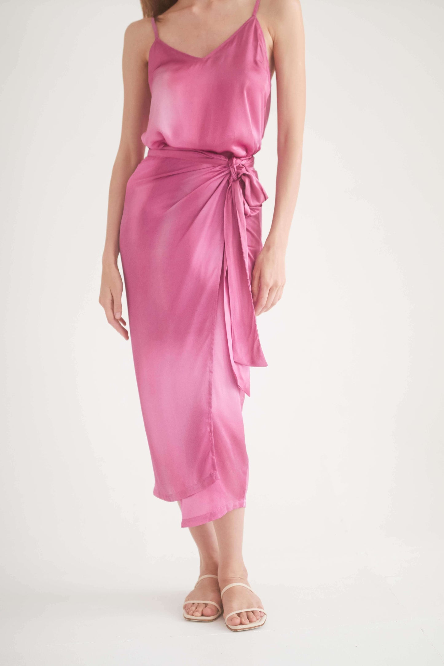 Model wearing a pink printed wrap midi skirt made from 100% Ecovero viscose, featuring a self-tie closure for versatile styling.