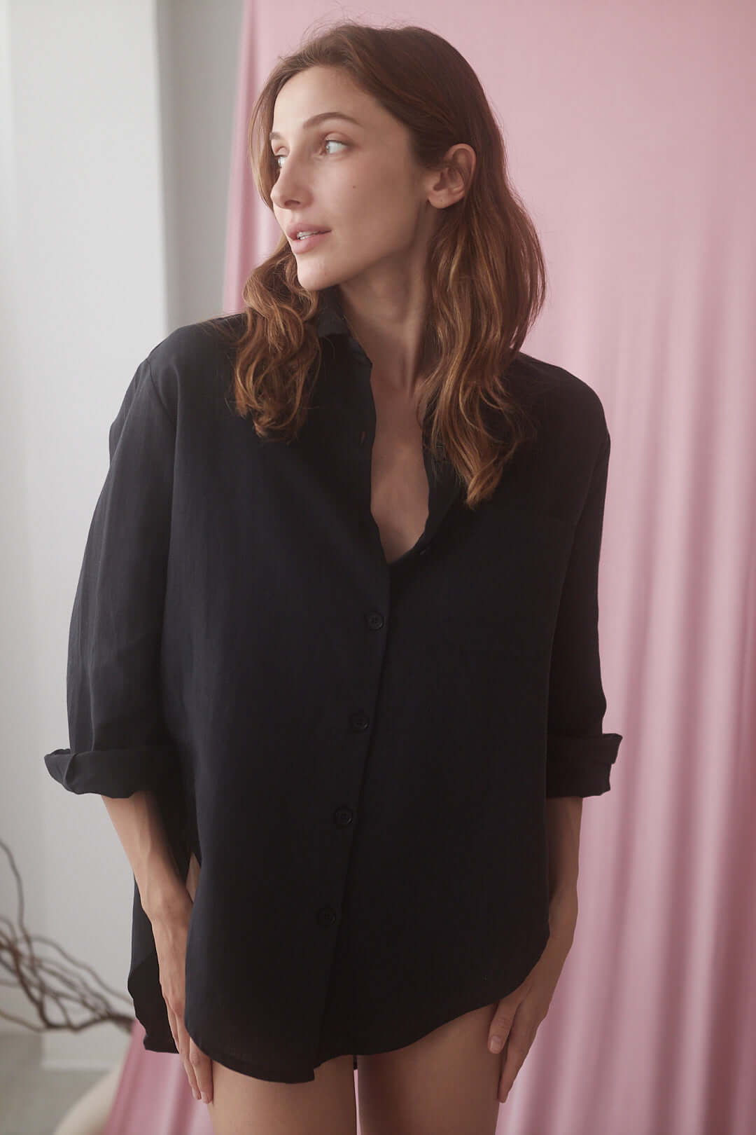 Model wearing a black wide shirt made from premium organic cotton and linen blend, draped elegantly against a soft background.