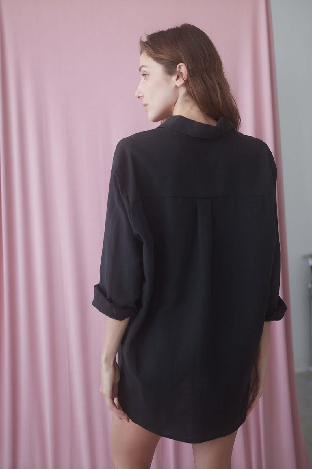 Model wearing a black wide shirt showcasing the back view, ideal for a stylish, effortless look.
