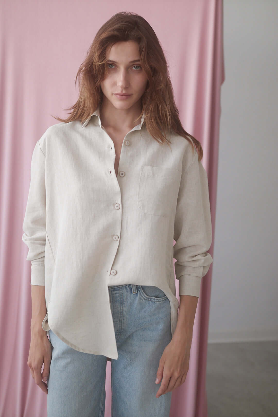 Model wearing a natural wide shirt made of organic cotton and linen blend, styled with casual jeans.