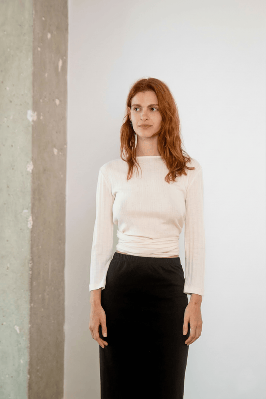 Model wearing Banana Pineapple Multiway Wrap Top in Ecru paired with a black skirt.