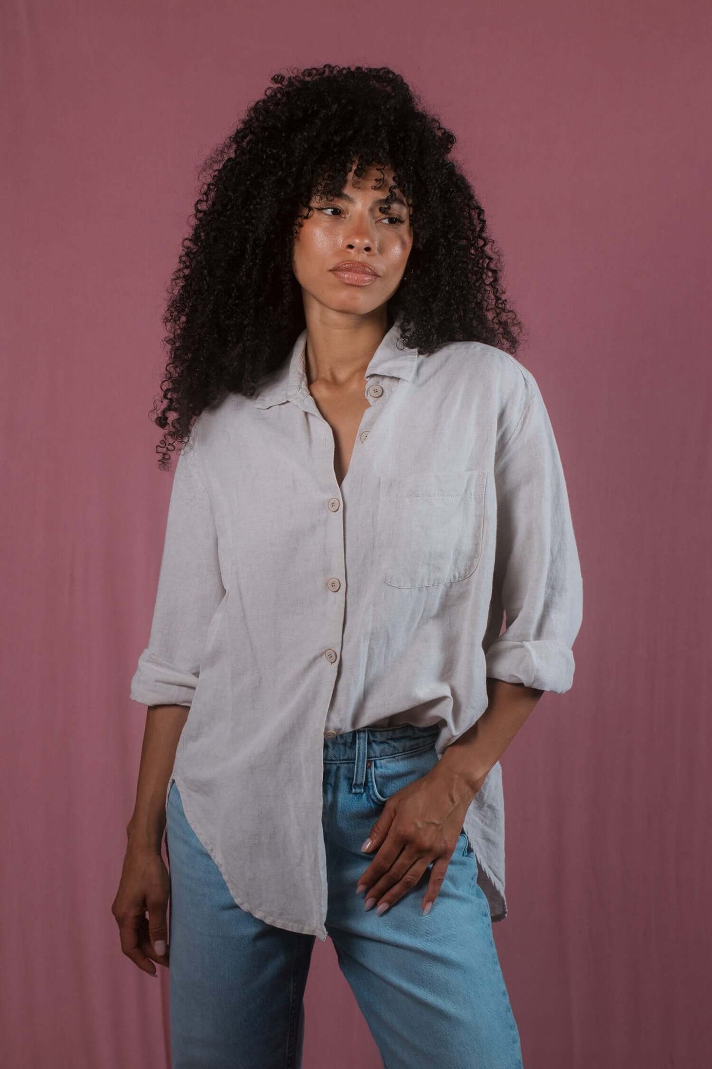 Model wearing a natural wide shirt made from organic cotton and linen blend, paired with jeans.