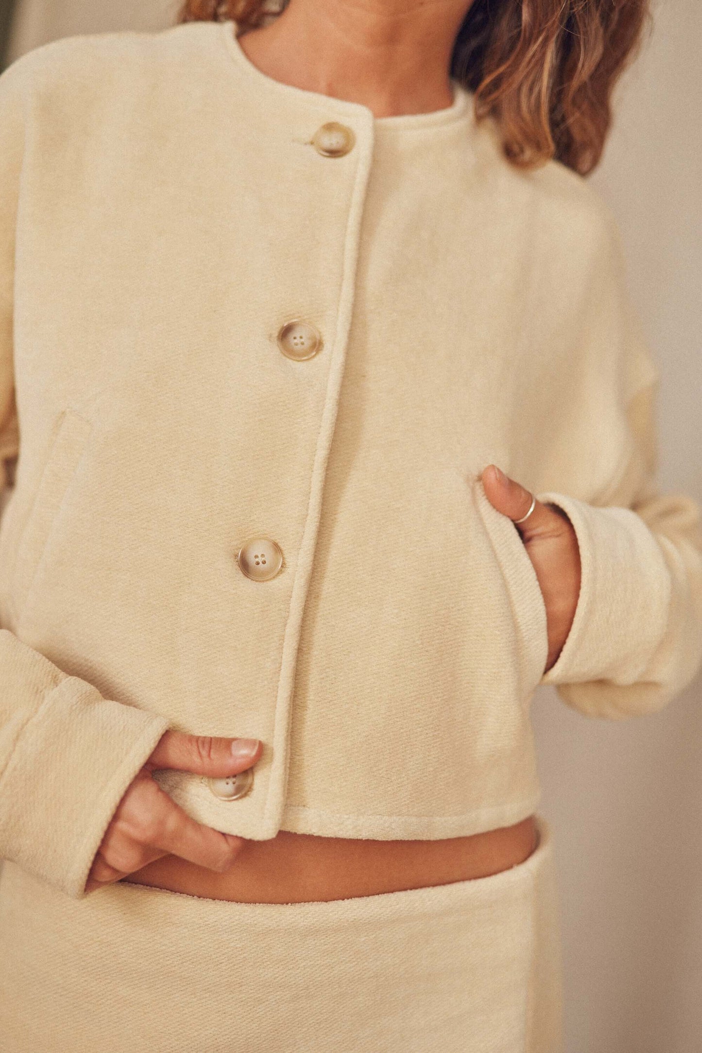 Oat organic cotton crop jacket featuring eco-friendly buttons and a bomber-inspired design, perfect for autumn layering.