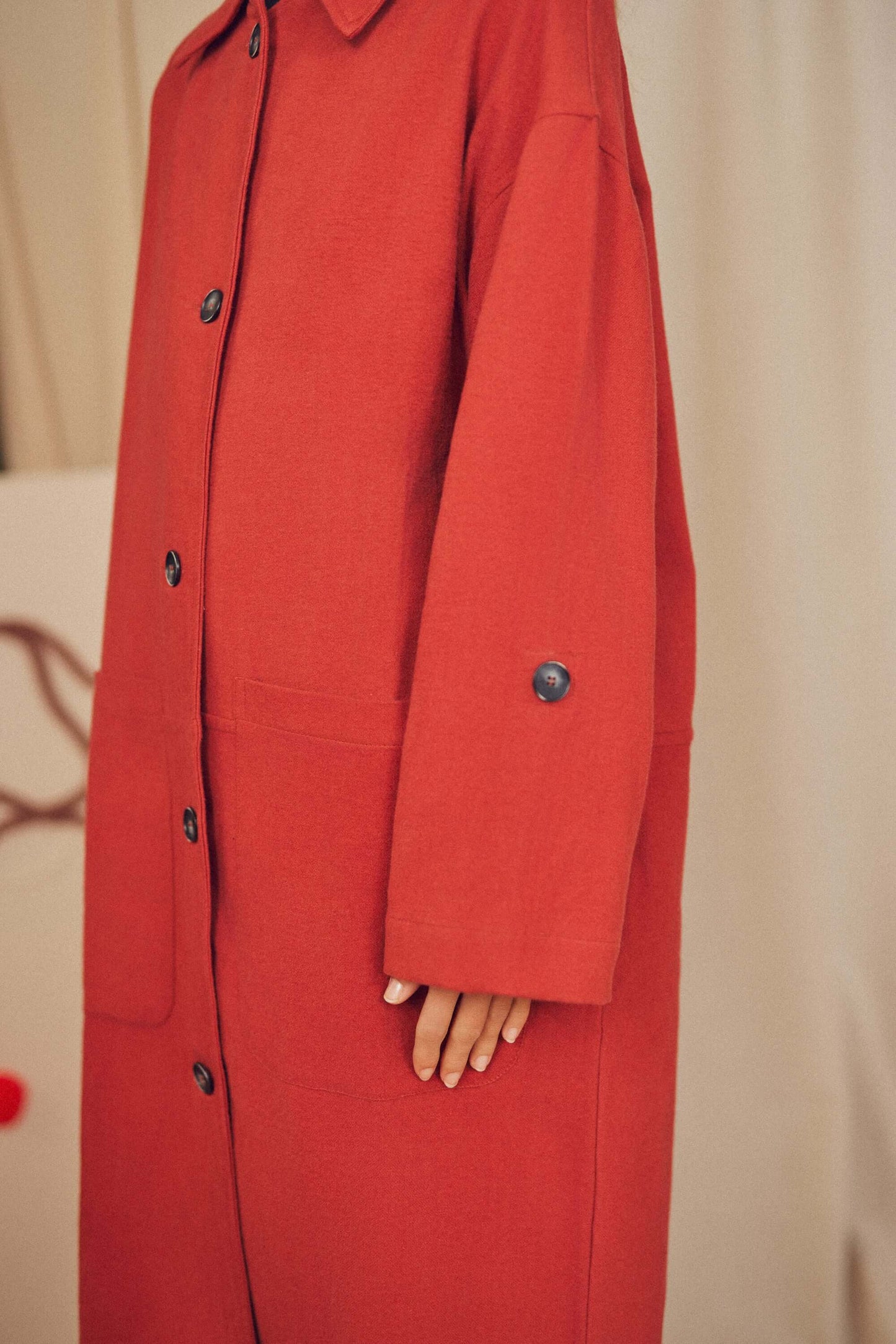 Woman wearing a rust wide coat.