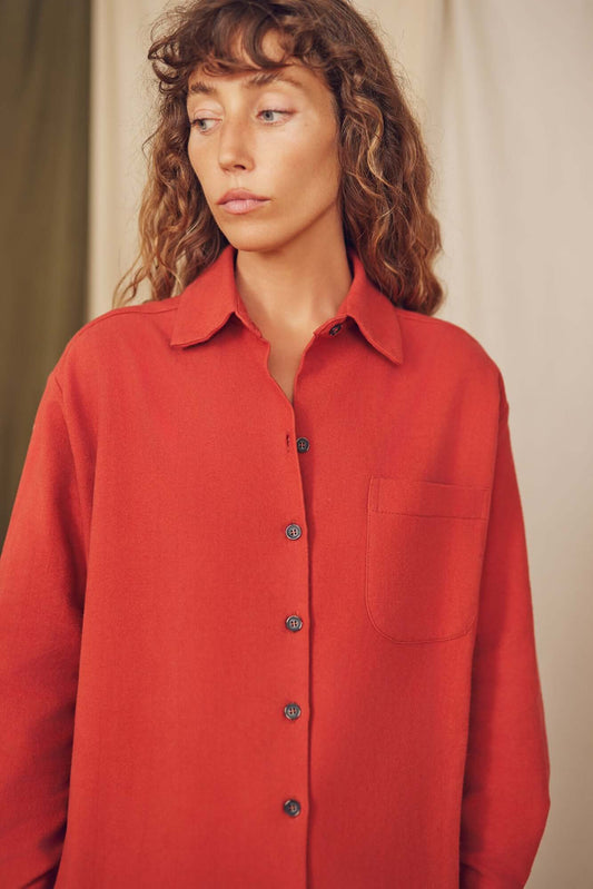 Model wearing a rust organic cotton wide overshirt with eco-friendly buttons and a minimalist design.