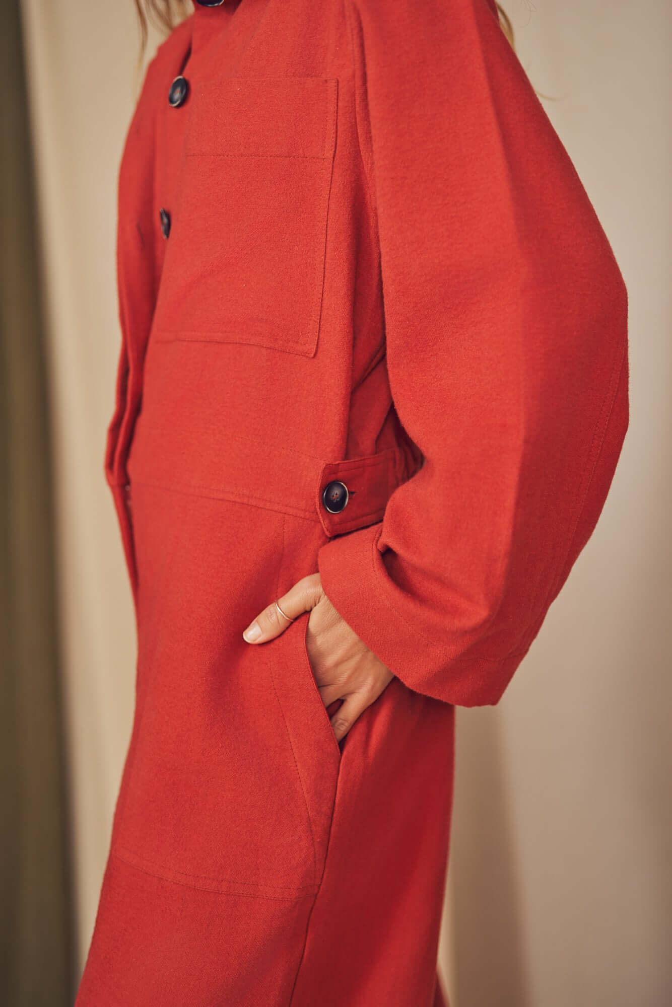 Woman wearing a rust colour boiler suit.