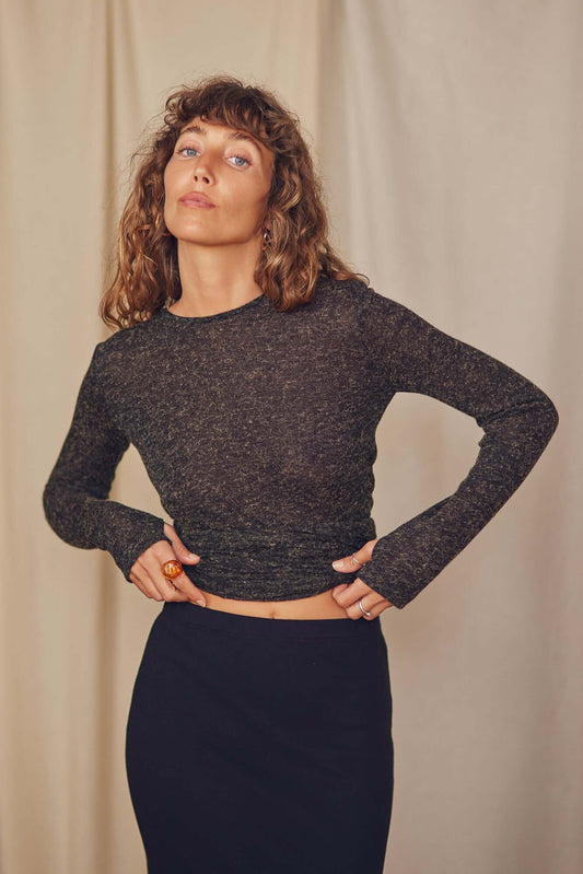 Model wearing a black multiway recycled jersey wrap top, showcasing a versatile style with long sleeves and a cropped design.