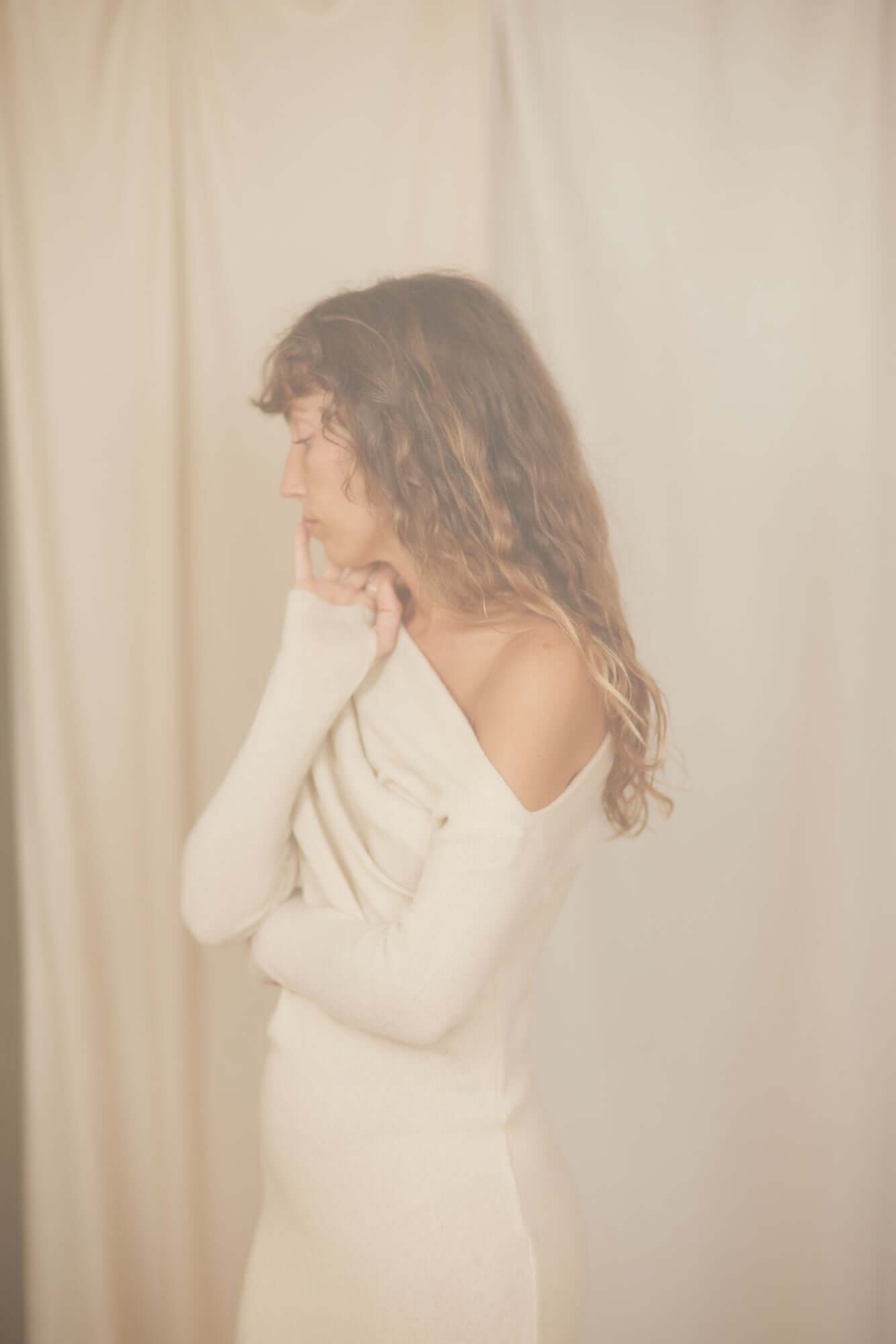 Woman wearing an Oat Fine Knit Drape Dress, showcasing the flattering drape neckline and elegant silhouette.