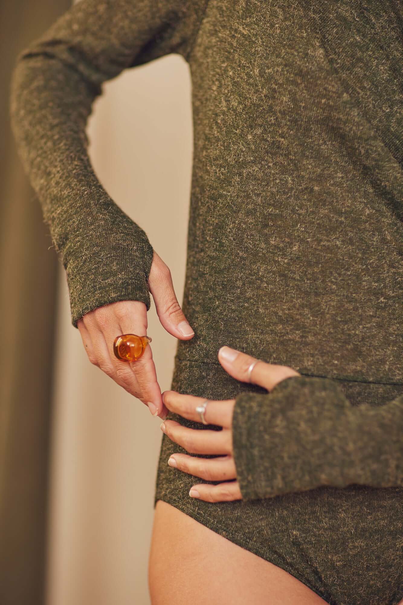 Model wearing khaki recycled jersey drape bodysuit with long sleeves and thumb holes, showcasing autumn style.