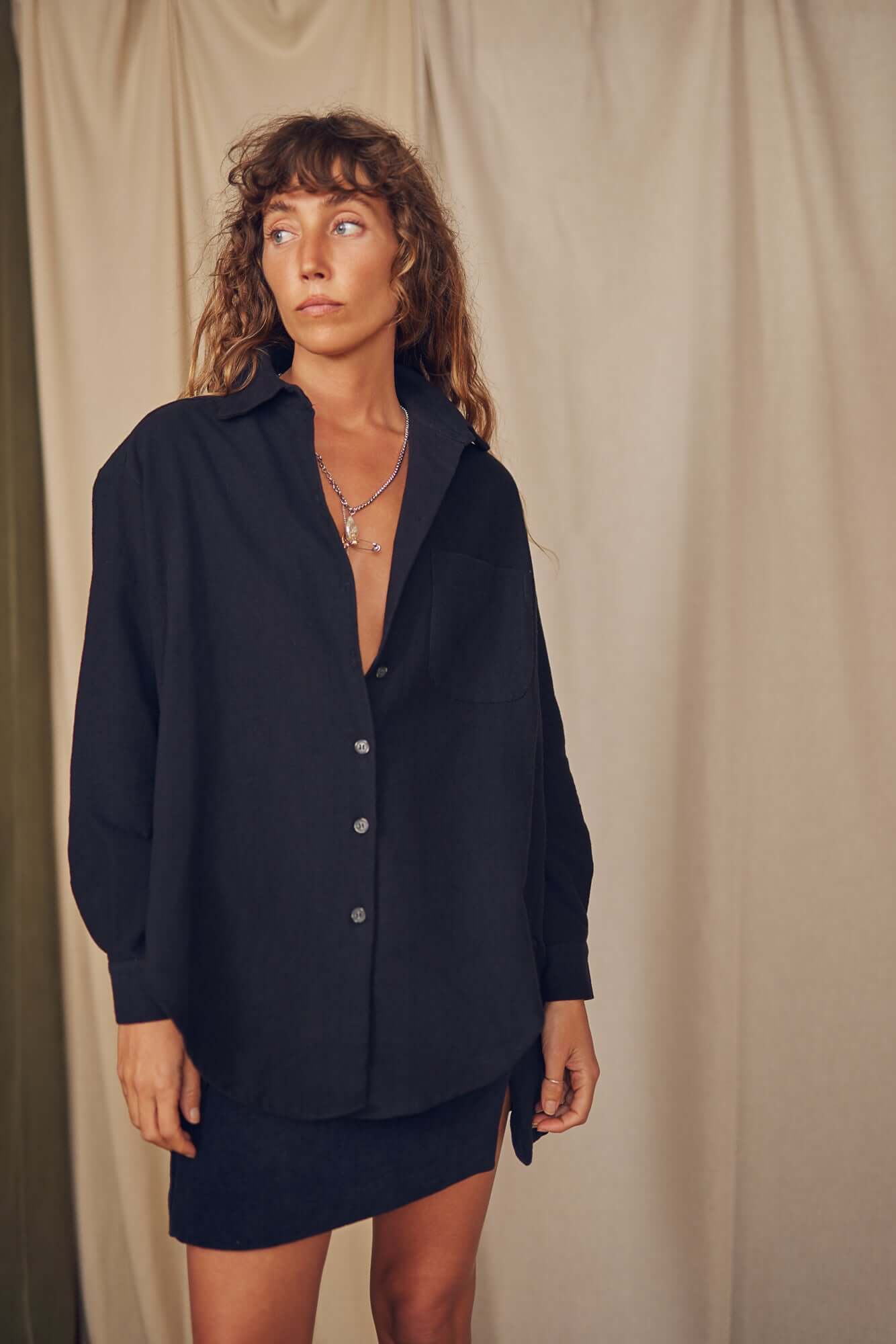 Model wearing a black organic cotton wide overshirt, styled casually, perfect for autumn layering.