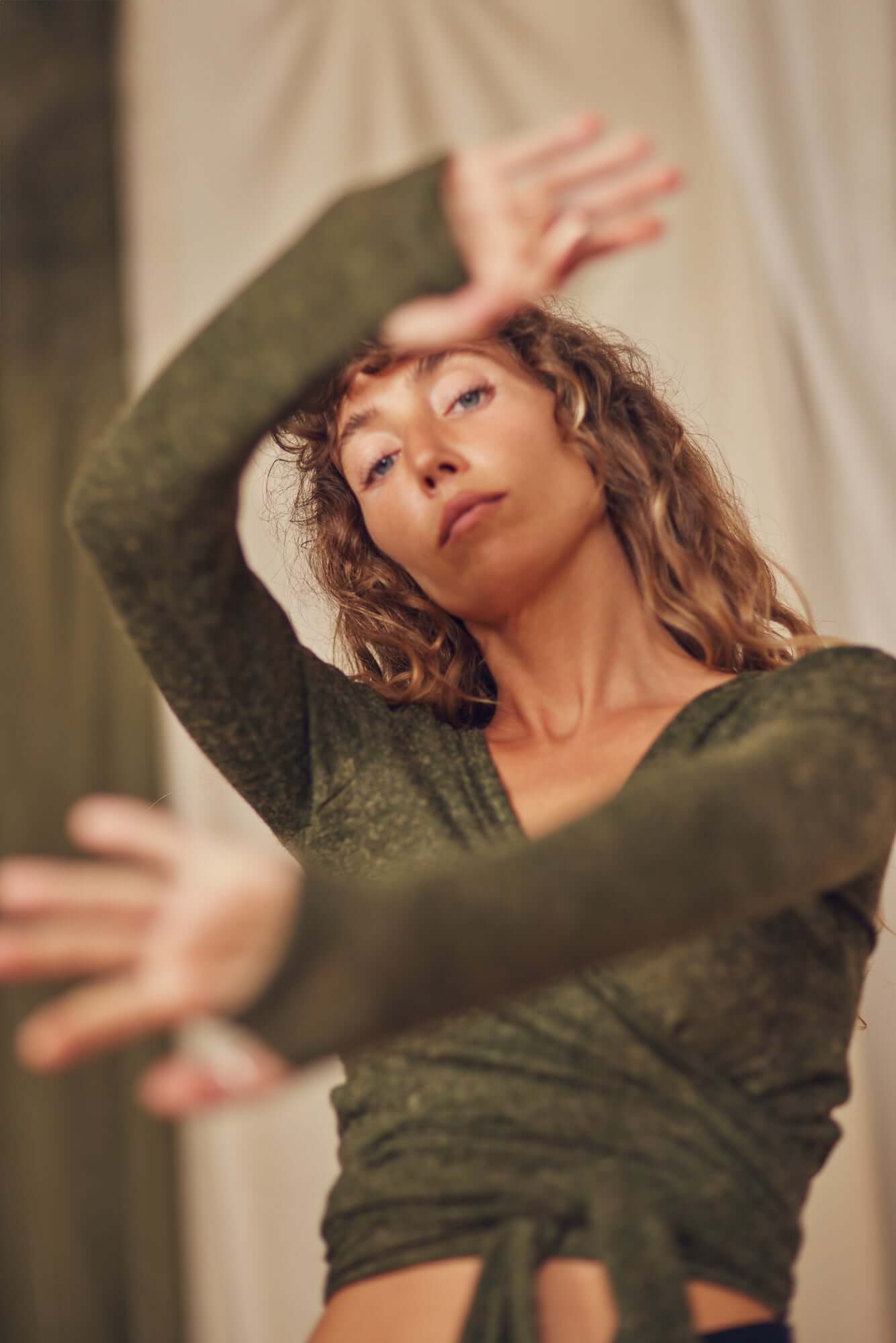 Khaki Multiway Recycled Jersey Wrap Top styled by model with curly hair, showcasing its versatility and comfort.