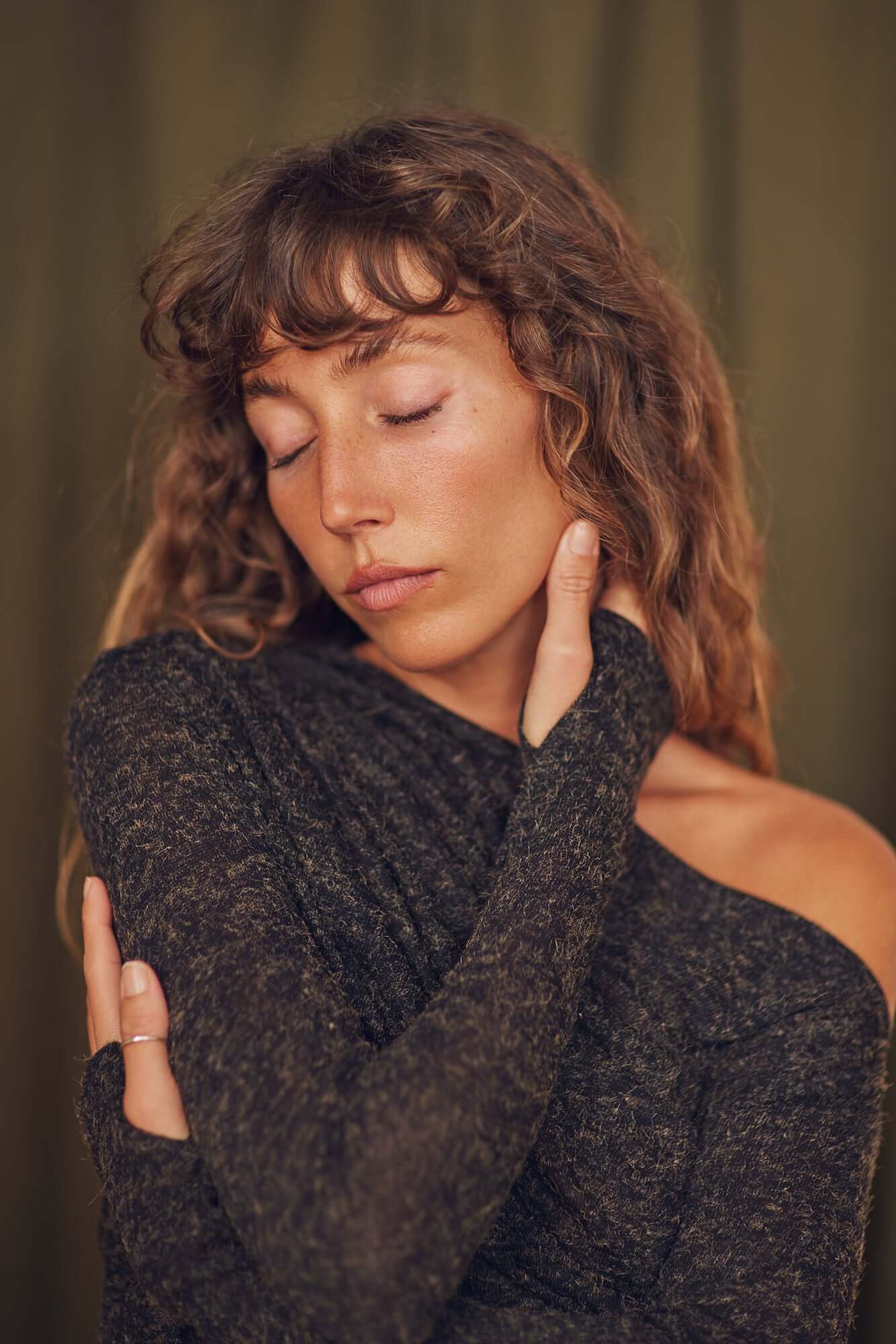 Model wearing a Black Recycled Jersey Drape Top showcasing stylish draped neckline and thumb holes for comfort.