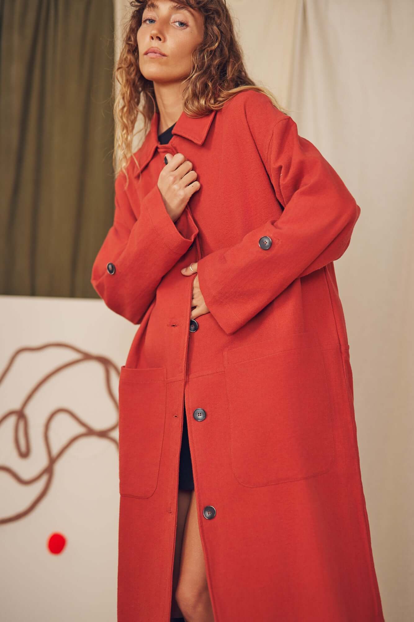 Woman wearing a rust wide coat.
