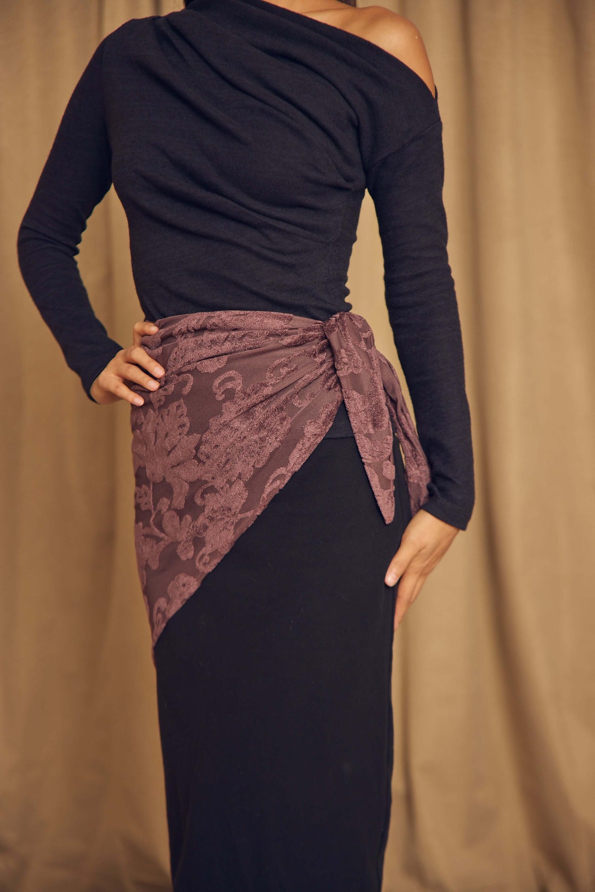Cocoa Devoré Triangle Scarf styled as a waist wrap over a long black dress, showcasing its versatility and intricate pattern.
