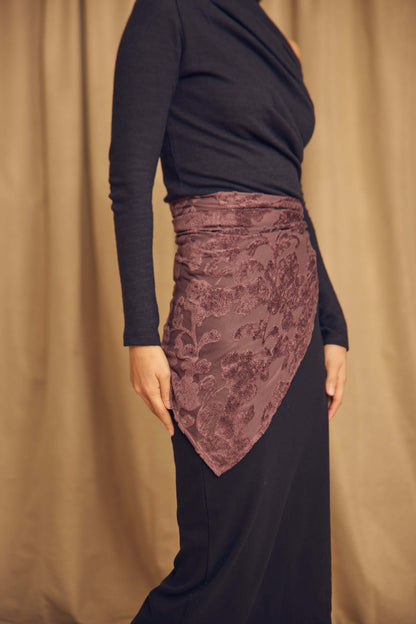 Cocoa Devoré Triangle Scarf styled as a wrap over a black dress, showcasing its intricate devoré pattern.