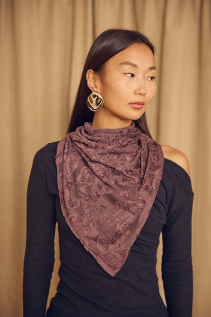 Cocoa Devoré Triangle Scarf styled as a neck wrap on a model with chic earrings, showcasing its intricate pattern and flow.