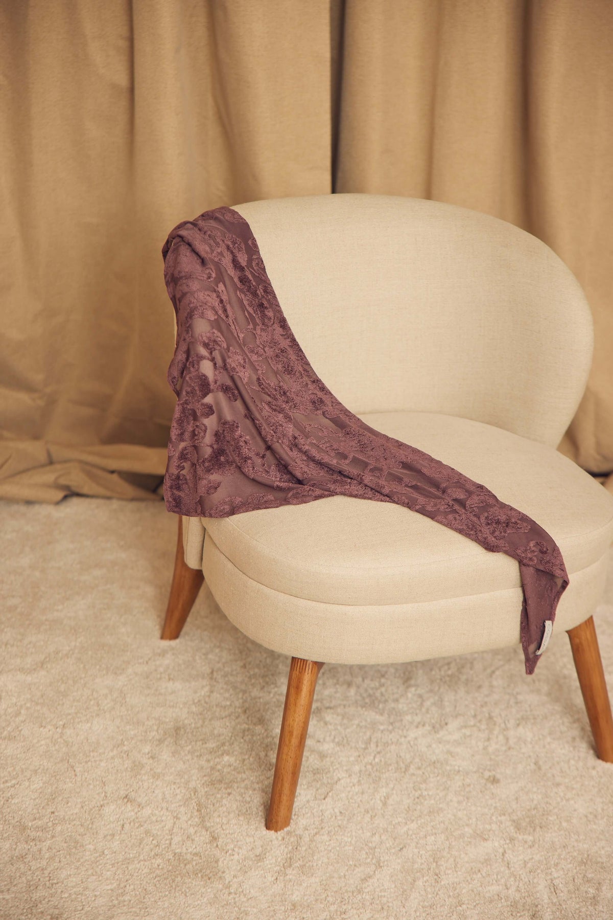 Cocoa Devoré Triangle Scarf draped on a modern chair showcasing its intricate pattern and lightweight fabric.