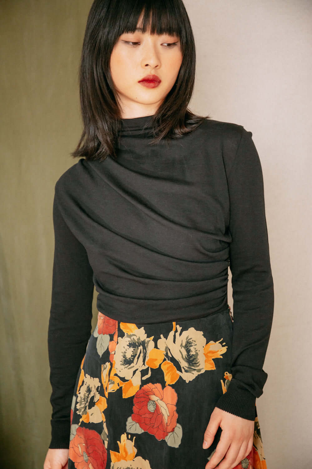 Woman wearing black drape knit top with floral skirt, an online exclusive made of lyocell and organic cotton, perfect for layering.