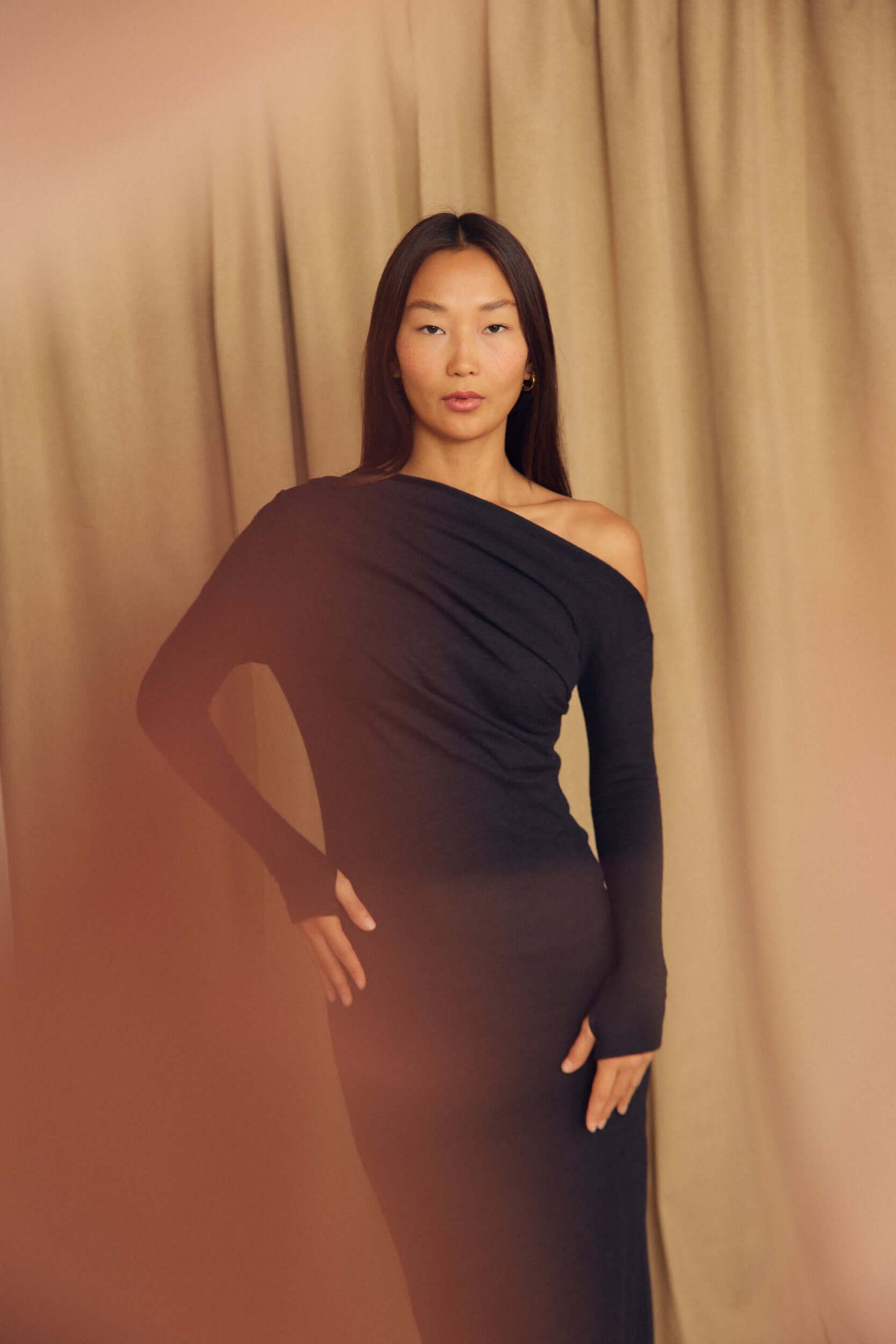 Black Wool Drape Midi Dress modeled by a woman with draped neckline against a soft background.