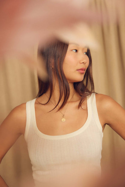 Ecru Lyocell Ribbed Tank Top modeled by a woman wearing a soft, streamlined fit tank top.