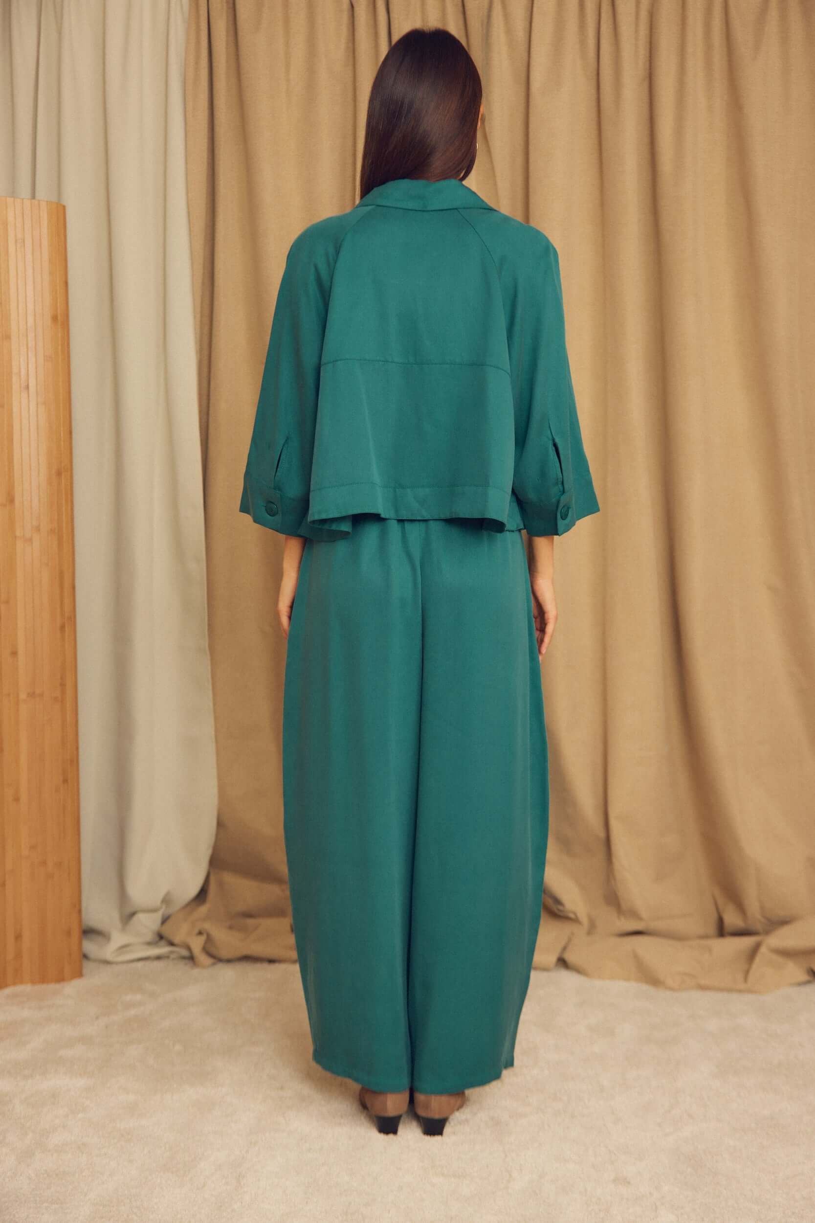Back view of a model wearing Teal Lyocell Barrel-Leg Trousers with a matching top.