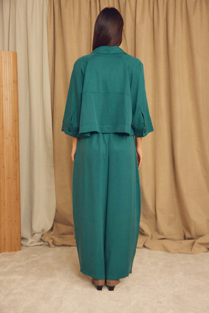 Back view of a model wearing Teal Lyocell Barrel-Leg Trousers with a matching top.