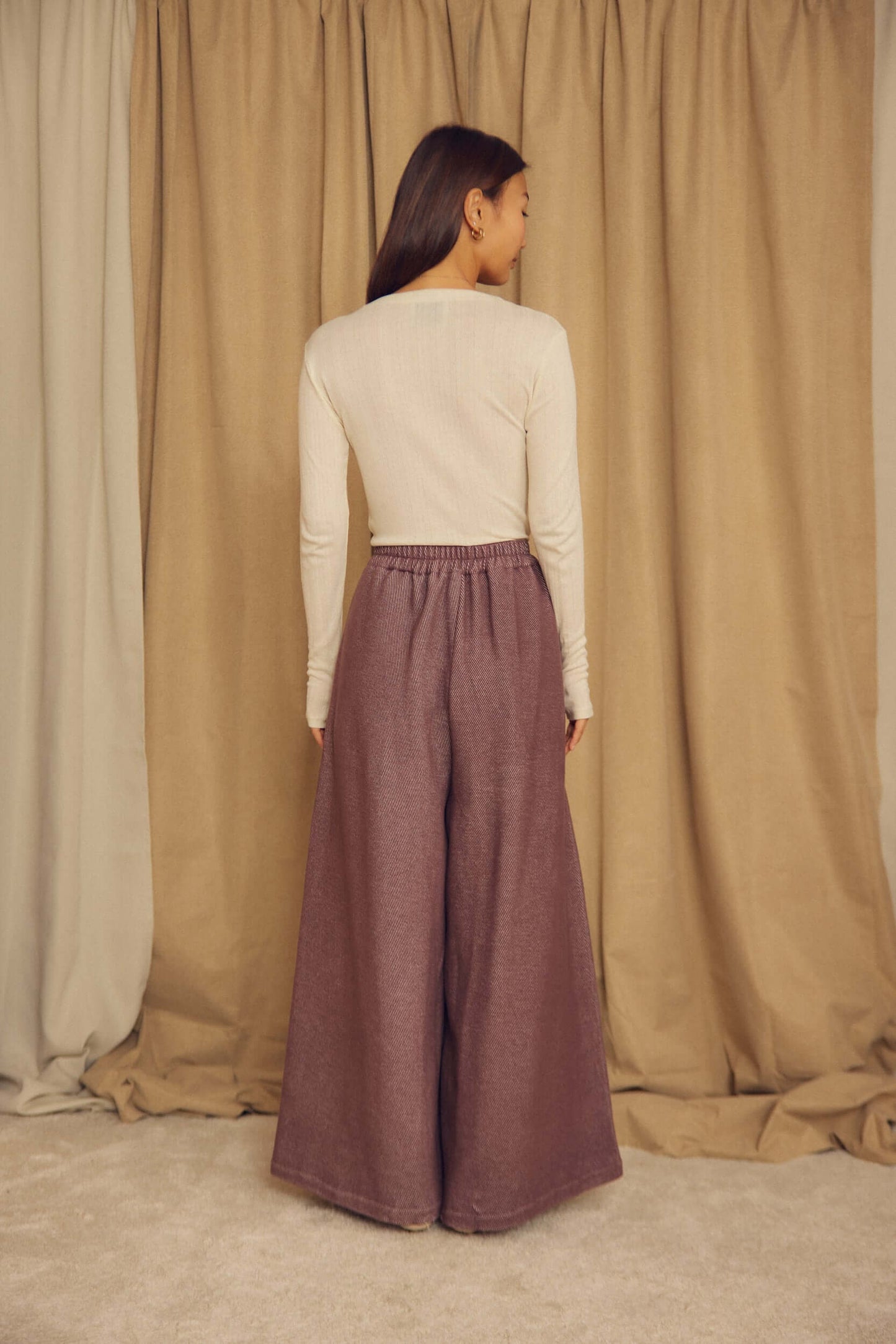 Model wearing Cocoa Organic Cotton Wide Trousers from the back, showcasing the oversized, wide-leg silhouette.