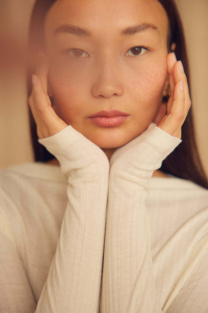 Ecru Lyocell Ribbed Long Sleeve Top worn by a model showcasing its soft, close-to-body fit and elevated design.