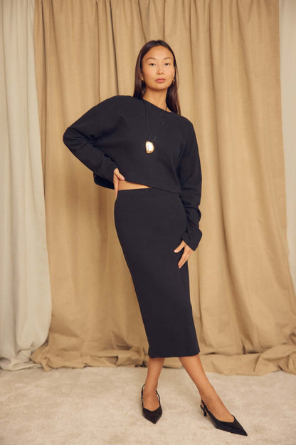 Black Organic Cotton Pencil Midi Skirt styled with a matching top, showcasing a chic and minimalist look.