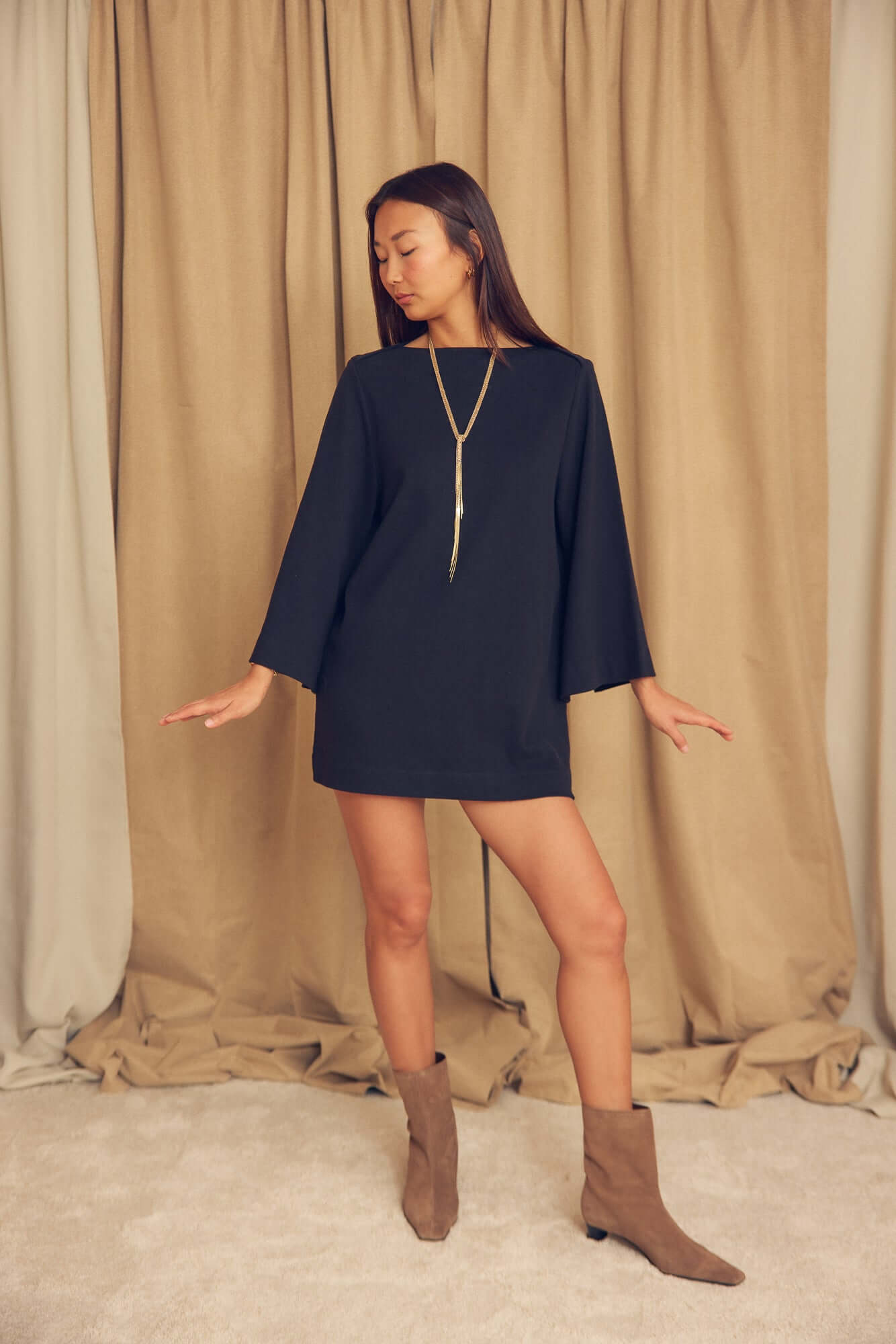 Black Organic Cotton Mini Dress with Flared Sleeves modeled by a woman in a studio setting.