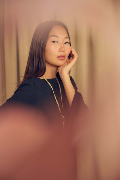 Black Organic Cotton Mini Dress with Flared Sleeves worn by a model posing elegantly.