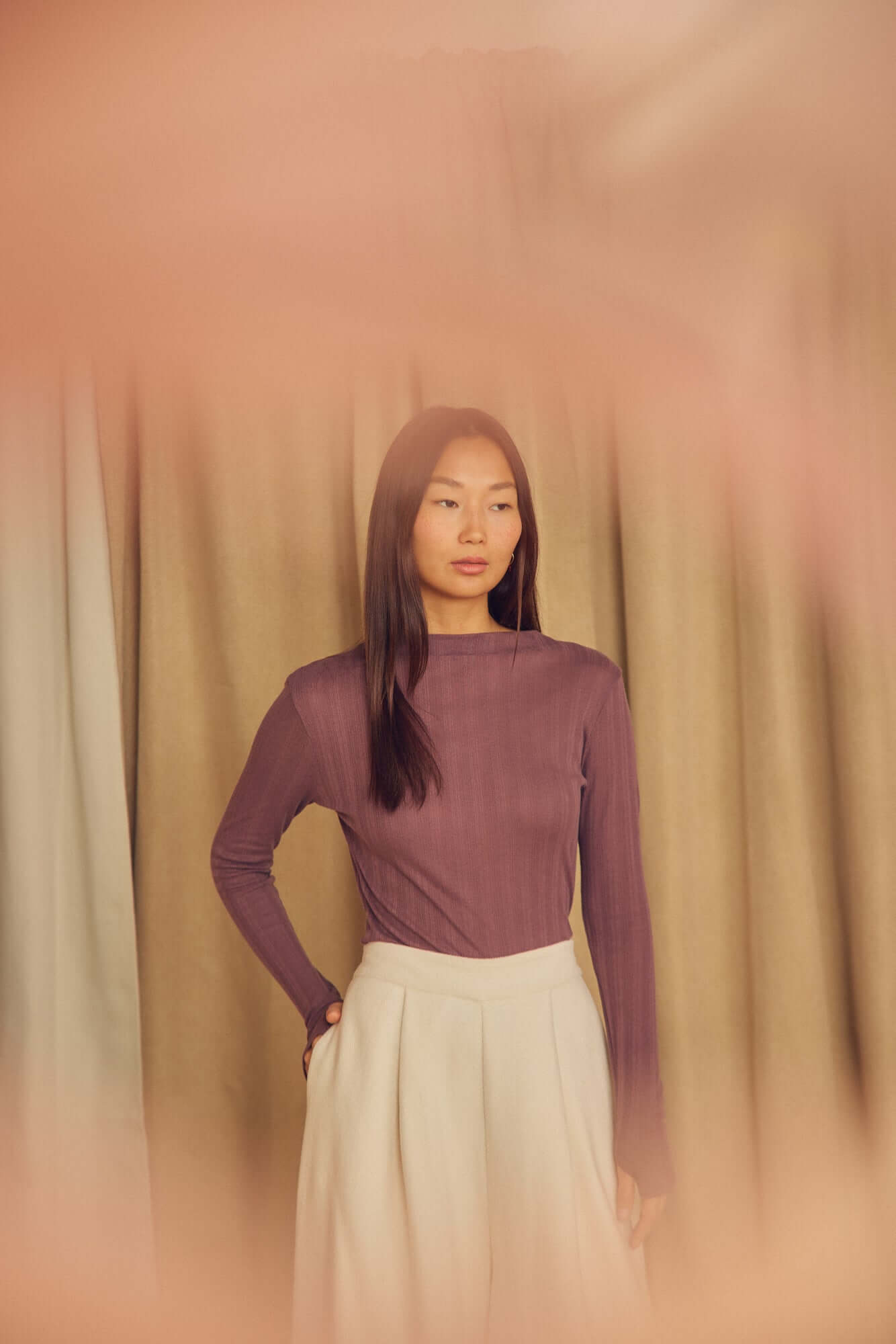 Model wearing Ecru Organic Cotton Wide Trousers with a fitted purple top against a soft backdrop.