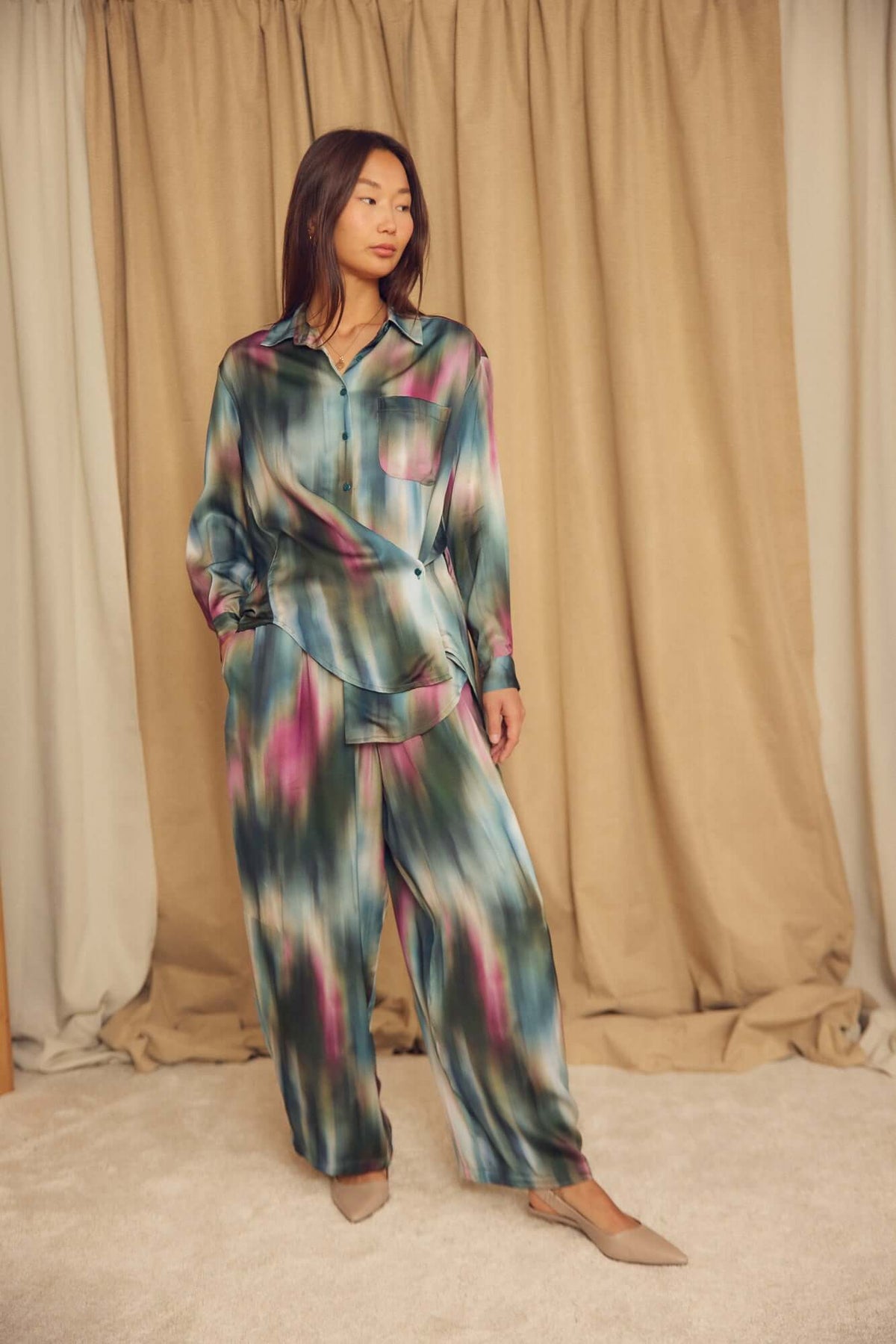 Model wearing Printed ECOVERO Viscose Barrel-Leg Trousers with a colorful patterned shirt, posing in a stylish setting.