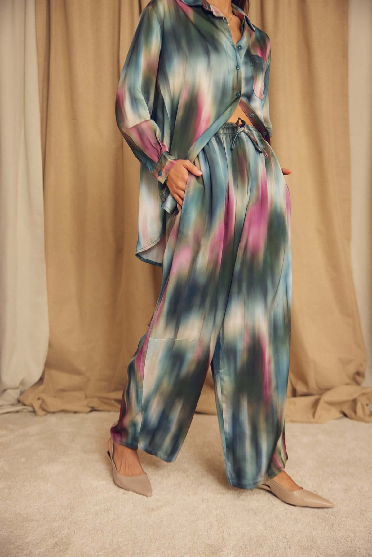 Model wearing Printed ECOVERO Viscose Barrel-Leg Trousers with a colorful, fluid design in a stylish setting.