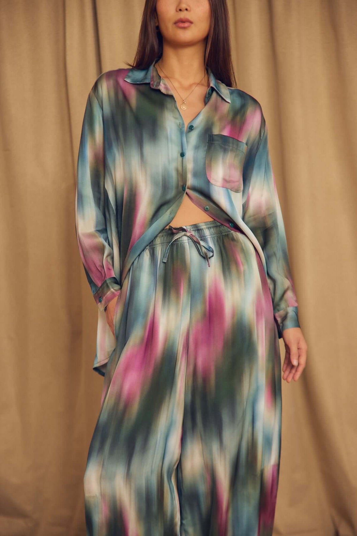 Model wearing Printed ECOVERO Viscose Barrel-Leg Trousers with a colorful patterned shirt.