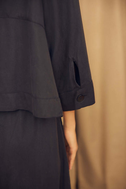 Black Lyocell Flared Jacket showcasing its elegant flared sleeve and eco corozo button detail.
