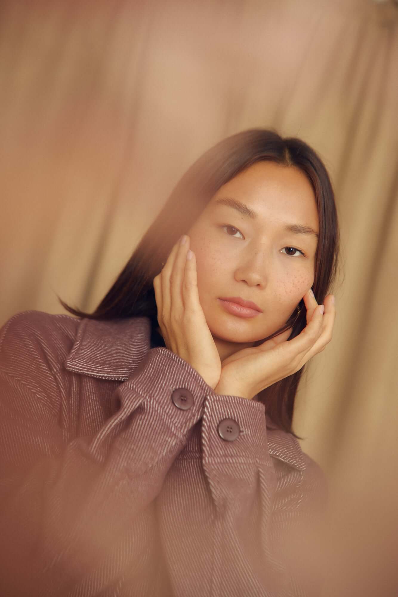 A woman wearing a Cocoa Organic Cotton Shacket, showcasing a relaxed silhouette and elegant styling.